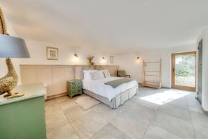 a bedroom with a bed and a table with a lamp at Tumbledown Barn in Knowstone