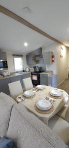 a kitchen with a table with plates on it at Beautiful Caravan With Decking Wifi At Isle Of Wight, Sleeps 4 Ref 84047sv in Porchfield