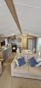 a living room with a couch and a kitchen at Beautiful Caravan With Decking Wifi At Isle Of Wight, Sleeps 4 Ref 84047sv in Porchfield