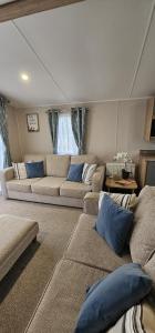 a living room with two couches and blue pillows at Beautiful Caravan With Decking Wifi At Isle Of Wight, Sleeps 4 Ref 84047sv in Porchfield