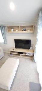 a living room with a flat screen tv in a room at Beautiful Caravan With Decking Wifi At Isle Of Wight, Sleeps 4 Ref 84047sv in Porchfield