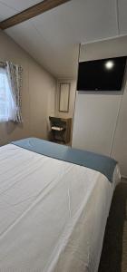 Tempat tidur dalam kamar di Beautiful Caravan With Decking Wifi At Isle Of Wight, Sleeps 4 Ref 84047sv