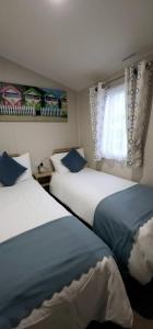 a hotel room with two beds and a window at Beautiful Caravan With Decking Wifi At Isle Of Wight, Sleeps 4 Ref 84047sv in Porchfield