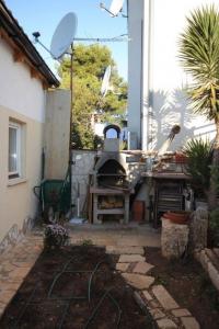 - une cuisine extérieure avec un barbecue dans la cour dans l'établissement Ferienwohnung für 6 Personen ca 45 qm in Pomer, Istrien Istrische Riviera, à Pomer