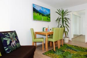 ein Esszimmer mit einem Tisch und grünen Stühlen in der Unterkunft RELAX - GREEN mit Pool und Sauna in Scheidegg