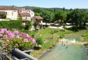 un grupo de personas nadando en un río en Maison médiévale avec jardin dans charmant village, en Vers