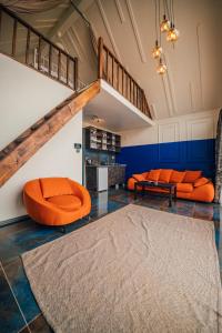 una sala de estar con muebles de color naranja y una escalera. en SNAİL HOUSE SAPANCA, en Sapanca