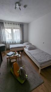1 dormitorio con 2 camas, mesa y silla en Ferienwohnung im Zenngrund en Neuhof an der Zenn