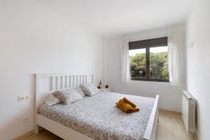 ein weißes Schlafzimmer mit einem Bett mit einem Teddybär darauf in der Unterkunft Modern and renewed Apartament Florí in Arenys de Mar