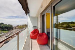 zwei rote Sitzsäcke auf dem Balkon eines Gebäudes in der Unterkunft Modern and renewed Apartament Florí in Arenys de Mar