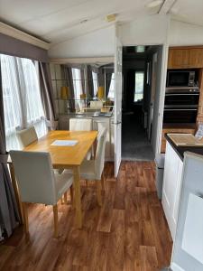 een eetkamer en een keuken met een tafel en stoelen bij 2 bedroom caravan, sea views, parking in Eastchurch