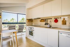 a kitchen with white cabinets and a table at APARTAMENTO SA PERDIU N 29 in Son Carrio