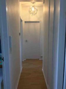 a hallway with a white door and a chandelier at Super-convenient, 3 mins to Kings Cross in London