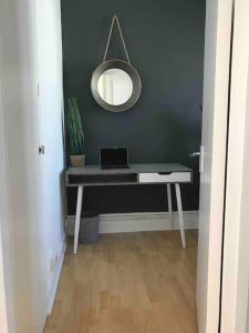 a desk with a laptop on it with a mirror at Super-convenient, 3 mins to Kings Cross in London