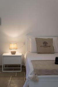 ein Schlafzimmer mit einem Bett mit einer Lampe auf einem Beistelltisch in der Unterkunft Guerrieri Suites & Spa in Campi Salentina