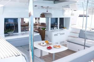 a table on a yacht with a plate of food on it at Catamaran Lagoon 450 in Ibiza Town