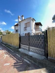 a fence in front of a white house at Sunny Room in a cozy Villa in Sperlonga