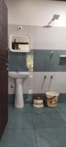 a bathroom with a sink and a toilet and a mirror at Katakeri Deluxe Holiday Homes in Madikeri