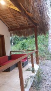 a bench under a thatched roof in a building at Bungalow nel verde in El Limón