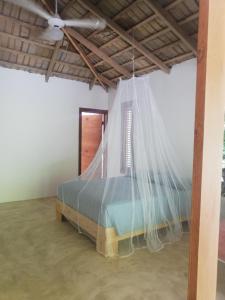 a bed in a room with a mosquito net at Bungalow nel verde in El Limón