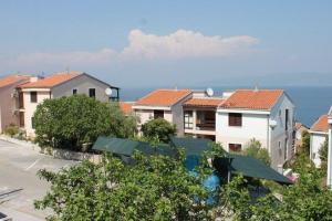 un groupe de maisons avec l'océan en arrière-plan dans l'établissement Ferienwohnung für 5 Personen ca 45 qm in Skvaranska, Istrien Bucht von Raša, à Ravni