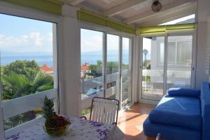 d'un balcon avec une table et un canapé offrant une vue sur l'océan. dans l'établissement Ferienwohnung für 5 Personen ca 45 qm in Skvaranska, Istrien Bucht von Raša, à Ravni