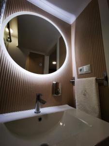 a bathroom with a sink and a large mirror at Apartamento ms in Campo Maior