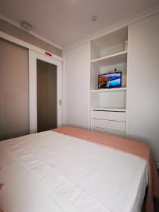 a bedroom with a bed and a tv on a wall at Apartamento ms in Campo Maior +9 photos