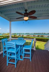 een blauwe tafel en stoelen op een terras met een plafondventilator bij Hawks Cay Resort in Marathon