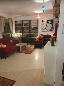 ein Wohnzimmer mit einem Sofa und einem Kühlschrank in der Unterkunft נווה מדבר in Jerusalem