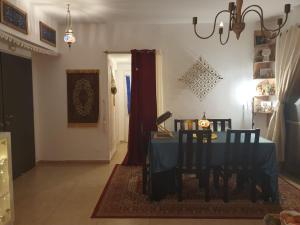 ein Esszimmer mit einem blauen Tisch und Stühlen in der Unterkunft נווה מדבר in Jerusalem