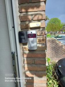 uma parede com dois telemóveis ao lado de uma casa em Rose huisje em Antuérpia