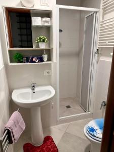 a white bathroom with a sink and a shower at San Lollo Room in Rome