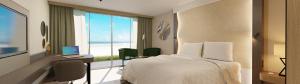 een hotelkamer met een bed en een bureau met een computer bij Strandhotel Het Hoge Duin in Wijk aan Zee