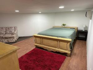 una camera con un letto, un divano e un tappeto rosso di Habitación para bajitos a San Luis Río Colorado
