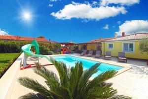 a swimming pool with a slide next to a house at Ferienhaus mit Privatpool für 8 Personen ca 130 qm in Loborika, Istrien Südküste von Istrien in Loborika