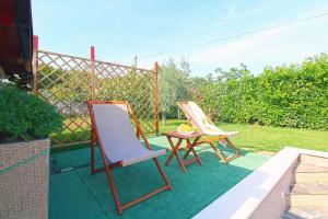 - une terrasse avec 2 chaises et une table dans l'établissement Ferienhaus mit Privatpool für 8 Personen ca 130 qm in Loborika, Istrien Südküste von Istrien, à Loborika