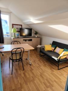 salon z kanapą i stołem w obiekcie Aux Oyats d Isa w mieście Fort-Mahon-Plage