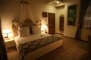 a bedroom with a large bed with two lamps at La Perla Boutique Hotel in İskenderun