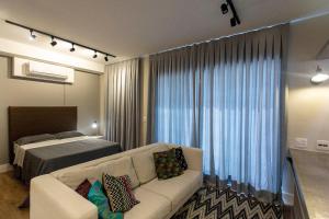 a living room with a couch and a bed at ADD Berrini in Sao Paulo