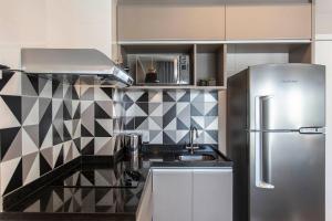 a kitchen with a sink and a refrigerator at ADD Berrini in Sao Paulo