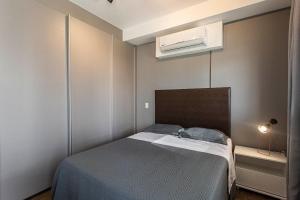 a small bedroom with a bed and a air conditioner at ADD Berrini in Sao Paulo