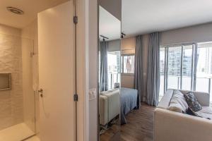 a room with a couch and a bed and a window at ADD Berrini in Sao Paulo