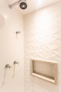a shower in a bathroom with white walls at ADD Berrini in Sao Paulo
