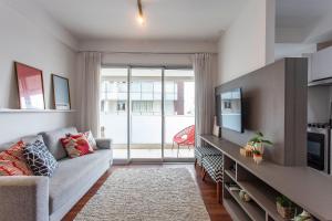 a living room with a couch and a tv at ADD Berrini in Sao Paulo