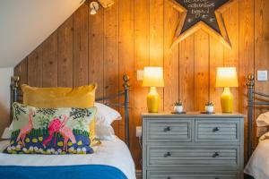 1 dormitorio con 1 cama con pared de madera en The Carriage House, en Stratford-upon-Avon