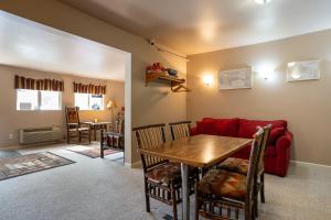 Una sala de estar con una mesa y un sofá rojo. en North Cascades Inn, en Marblemount