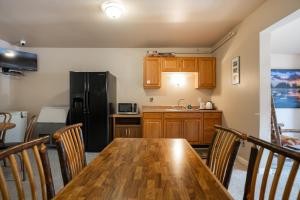 cocina con mesa de madera y nevera negra en North Cascades Inn, en Marblemount