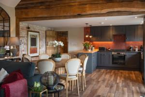 亞芬河畔史特拉福的住宿－The Blended Barn，厨房以及带桌椅的起居室。