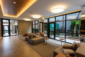 a large living room with couches and windows at Is Moema in Sao Paulo